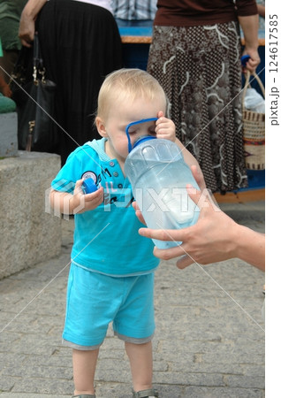 Toddler Drinking Water From a Large Bottle Outdoors Toddler Drinking Water From a Large Bottle Outdoors 124617585