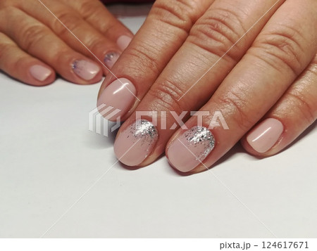 Pink natural nude look style womanly naildesign. Beautiful professional short naildesign on manicured healthy hands of european woman. Manicure gel polish nude and French 124617671