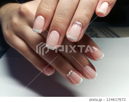 Pink natural nude look style womanly naildesign. Beautiful professional short naildesign on manicured healthy hands of european woman. Manicure gel polish nude and French 124617672