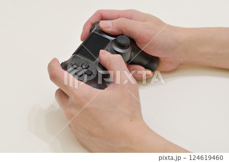 コントローラーでゲーム操作をしている手元 124619460