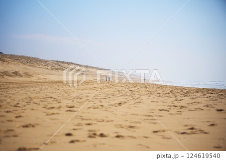 Couple Walking on Empty Sandy Beach 124619540