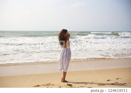 Woman Looking at Ocean on Sandy Beach 124619551