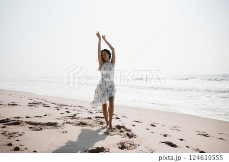 Joyful Woman Dancing Barefoot on Beach Joyful Woman Dancing Barefoot on Beach 124619555