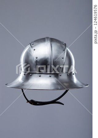 Silver Helmet with Wide Brim and Rivets. This image shows a shiny silver helmet featuring a wide, downward-sloping brim and several small rivets along its edges and the crown. 124619576
