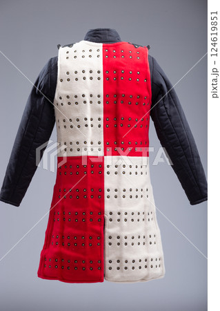 Red and White Brigandine Armor with Studs and Black Straps. This image shows a brigandine armor that is divided vertically into two halves, one red and the other white. It features rows of small Red and White Brigandine Armor with Studs and Black Straps. This image shows a brigandine armor that is divided vertically into two halves, one red and the other white. It features rows of small 124619851