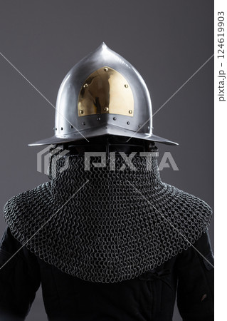 Elegant Medieval Helmet with Gold Accent and Chainmail. Sophisticated head protection featuring a polished finish, golden detail, and attached chainmail. 124619903