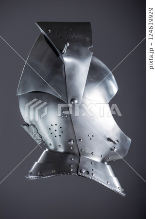 Silver Medieval Helmet with Lifted Visor. A polished silver helmet with a visor slightly raised, revealing a glimpse inside. 124619929