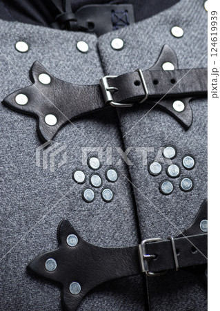 Close-up of Brigandine Armor Leather Straps and Rivets. Detailed view of the gray brigandine showing the leather straps, buckles, and metal rivet construction. 124619939
