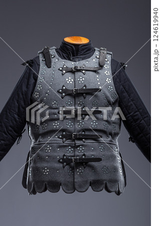 Gray Medieval Brigandine Armor with Leather Straps. This gray brigandine features overlapping metal plates riveted to a fabric base, secured with leather straps. 124619940