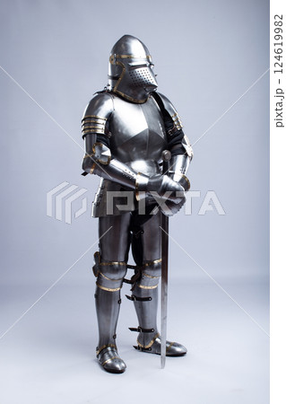 Full Suit of Fourteenth Century Knight's Plate Armor. Impressive display of medieval protective gear, including helmet, breastplate, gauntlets, and greaves 124619982