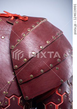 Close-up of Brown Leather Fantasy Shoulder Armor. Detailed view of the shoulder piece with rivets and red lacing. 124619991