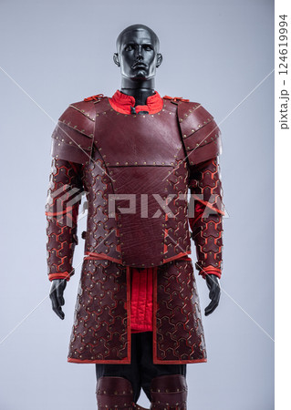 Brown Leather Fantasy Armor Set for LARP Cosplay. Full costume on a mannequin with intricate details and red accents. Brown Leather Fantasy Armor Set for LARP Cosplay. Full costume on a mannequin with intricate details and red accents. 124619994