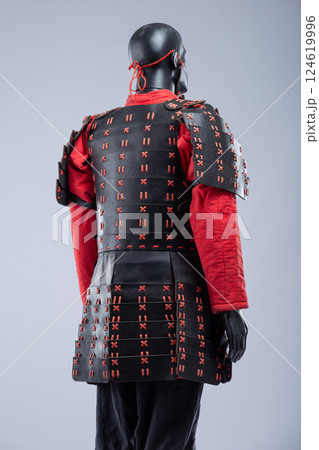 Black and Red Leather Armor Set on Mannequin. Full medieval warrior outfit with detailed stitching and metal accents. 124619996