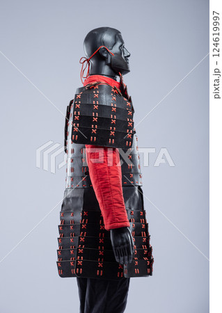 Black and Red Leather Armor Set on Mannequin. Full medieval warrior outfit with detailed stitching and metal accents. 124619997