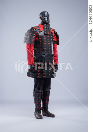 Full Black and Red Leather Armor Set on Mannequin. Warrior costume with cuirass, padded jacket, pants, and leg protection. Full Black and Red Leather Armor Set on Mannequin. Warrior costume with cuirass, padded jacket, pants, and leg protection. 124620002