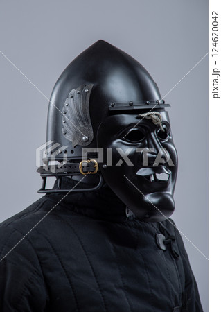 Black Steel Helmet with Face Mask. Grotesque medieval head protection with decorative wings. Black Steel Helmet with Face Mask. Grotesque medieval head protection with decorative wings. 124620042