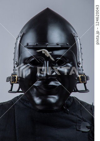 Black Steel Helmet with Face Mask. Grotesque medieval head protection with decorative wings. 124620043