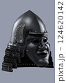 Dark Samurai Helmet with Menacing Face Mask. This image features a dark, almost black, samurai helmet with a detailed face mask displaying a fierce expression. 124620142