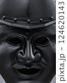 Dark Samurai Helmet with Menacing Face Mask. This image features a dark, almost black, samurai helmet with a detailed face mask displaying a fierce expression. 124620143