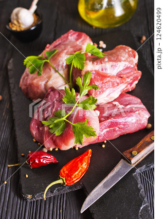 Raw meat with herbs and spices ready for cooking are on wooden table Raw meat with herbs and spices ready for cooking are on wooden table 124620499