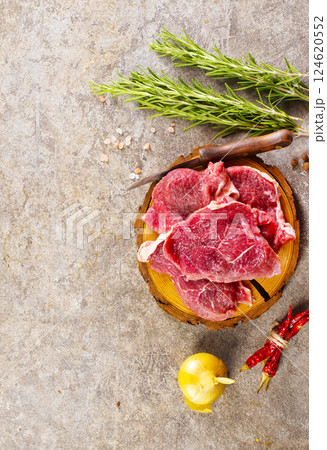 Raw meat with herbs and spices ready for cooking are on wooden table 124620552
