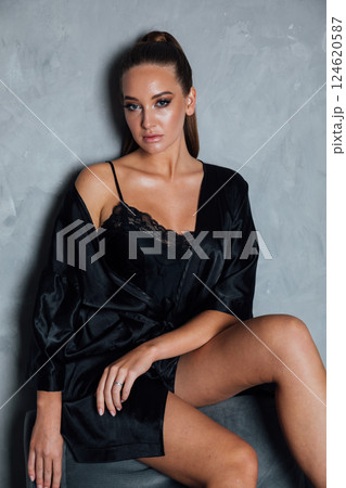 Portrait of Beautiful Woman in Black Silk Dress on Dark Background Portrait of Beautiful Woman in Black Silk Dress on Dark Background 124620587