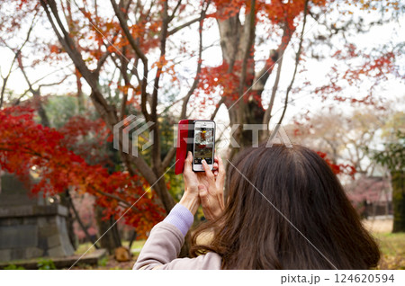 スマホで紅葉を撮影する女性 124620594