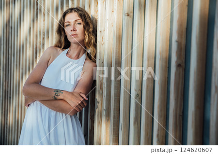 woman in light summer dress smiling in park on walk woman in light summer dress smiling in park on walk 124620607