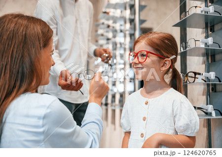 Woman, man and little girl is choosing right glasses for correcting vision Woman, man and little girl is choosing right glasses for correcting vision 124620765