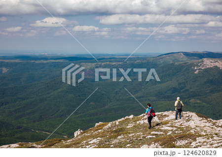 Two female traveler looking at the view from the top of the mountain on a hike 124620829