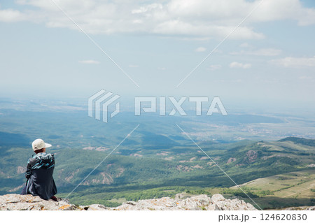 Female traveler looking at the view from the top of the mountain on a hike 124620830