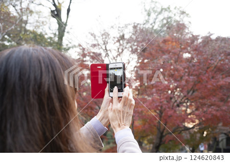 スマホで紅葉を撮影する女性 124620843