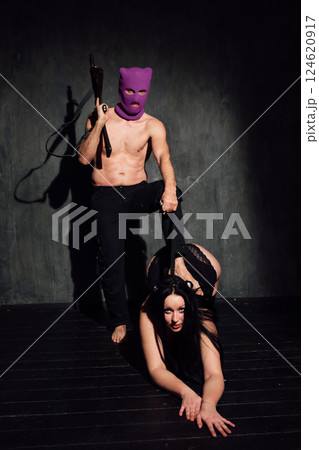 man and woman in black lingerie on dark background with guns man and woman in black lingerie on dark background with guns 124620917