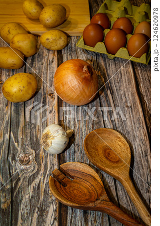 potatoes, onion, eggs, garlic and a couple of wooden spoons potatoes, onion, eggs, garlic and a couple of wooden spoons 124620978
