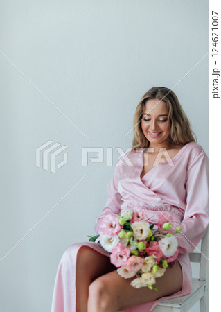 fashionable woman in light pink dress with bouquet of flowers fashionable woman in light pink dress with bouquet of flowers 124621007
