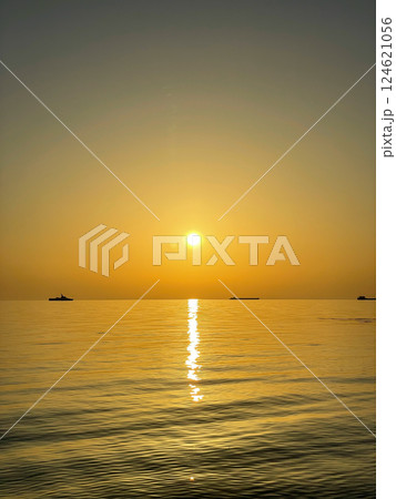 Silhouettes of ships on the horizon of the sea at sunset Silhouettes of ships on the horizon of the sea at sunset 124621056