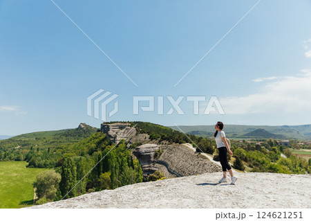 Female traveler looking at the view from the top of the mountain on a hike 124621251