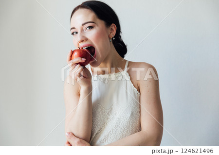 Beautiful brunette woman eating red apple on white background 124621496