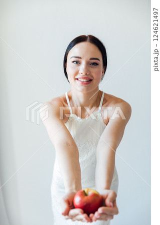 brunette woman holding red apple for diet on white background 124621497