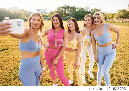 Taking a selfie. Group of women have fitness outdoors on the field together Taking a selfie. Group of women have fitness outdoors on the field together 124622908