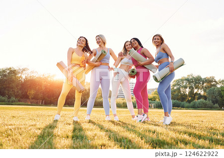 Standing and posing. Group of women have fitness outdoors on the field together 124622922