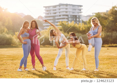 Conception of teamwork. Group of women have fitness outdoors on the field together Conception of teamwork. Group of women have fitness outdoors on the field together 124623123