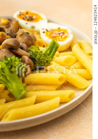 Pasta with fried mushrooms and broccoli, green peas and corn, fresh mix salad 124623414