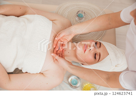 Masseur Giving Facial Massage To Woman In Spa Masseur Giving Facial Massage To Woman In Spa 124623741