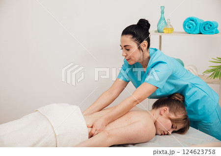 chiropractor doing medical back massage to woman in spa chiropractor doing medical back massage to woman in spa 124623758