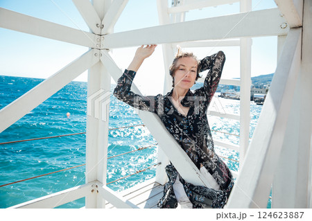 Beautiful woman of 40 years old walking on the beach by the sea Beautiful woman of 40 years old walking on the beach by the sea 124623887