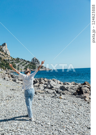 woman of 40 years old walking on the beach by the sea alone 124623888