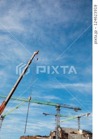Construction cranes for building houses against blue sky background 124623919
