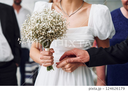 Close up view of hands with flowers. Beautiful bride with his fiance is on the wedding Close up view of hands with flowers. Beautiful bride with his fiance is on the wedding 124626179