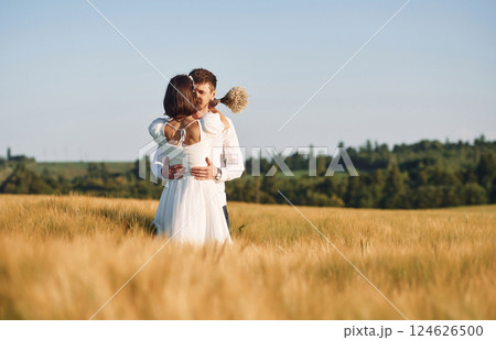 Couple just married. Together on the majestic agricultural field at sunny day 124626500